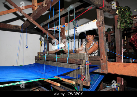 A process of Ikat fabric weaving. Weaving on a footloom. Stock Photo