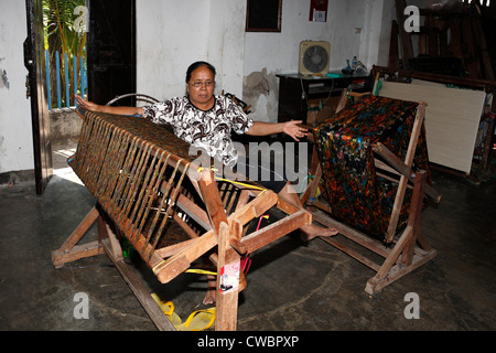 A process of Ikat fabric weaving. Separating the multicolored weft threads. Stock Photo