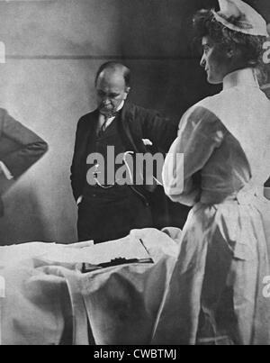 Sir William Osler (1849 – 1919), reading a patient's chart at bedside as a nurse watches. Osler was the first professor of Stock Photo