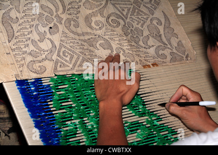 A process of Ikat fabric weaving. Preparing the thread for dyeing. Stock Photo