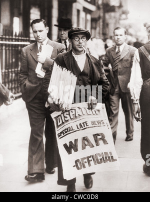 World War II. Announcing state of war with Germany, a British Newspaper man holding stack of newspapers and sign stating Stock Photo