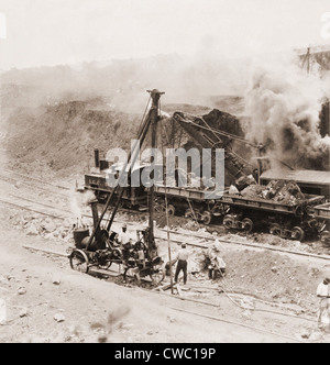 Panama Canal construction. A steam shovel loads excavated rocks into railroads cars at Gatun Dam site, Panama Canal Zone. 1910. Stock Photo