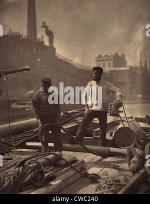 WORKERS ON THE SILENT HIGHWAY 1877 by John J. Thomson 1837-1921 shows two workmen on a barge on the Thames River England. Stock Photo