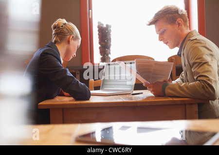 Business couple sitting in a restaurant and working Stock Photo