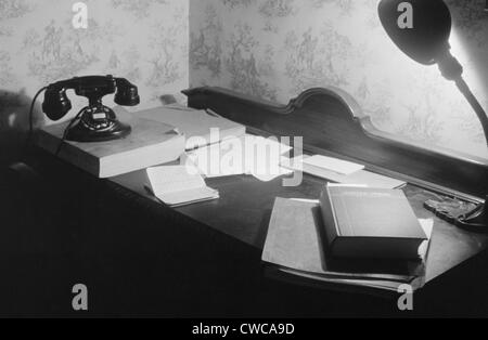 A US government clerk's home office desk with books, telephone and directory, and a desk lamp. Washington, D.C. 1939. Stock Photo