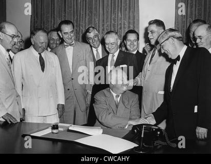 President Eisenhower signs a bill as Senate Majority Leader, Lyndon Johnson, and others look on. Johnson is fifth from left Stock Photo