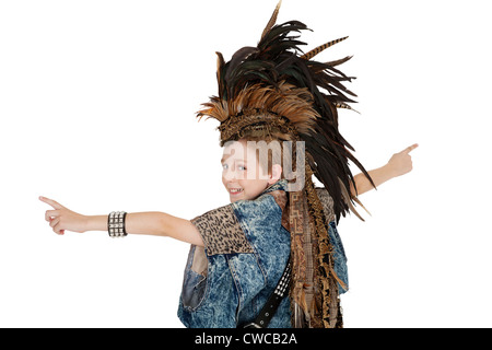 Portrait of boy in costume with headdress looking back over white background Stock Photo