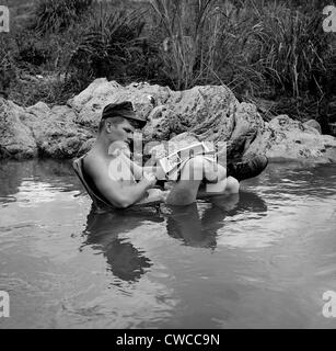 Vietnam War. US Marine rifleman takes time out to relax in a cool mountain stream, with an easy chair and his favorite