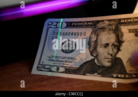 Checking US 20 Dollar bill under UV light Stock Photo