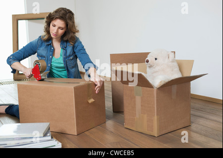 Woman taping up cardboard box Stock Photo