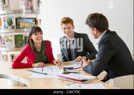 Real estate agent discussing property documents to his clients Stock Photo