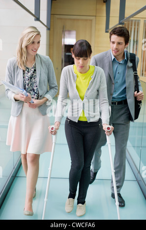 Disable woman walking with business executives in an office corridor Stock Photo