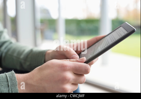 Close-up of a man's hand holding a digital tablet Stock Photo