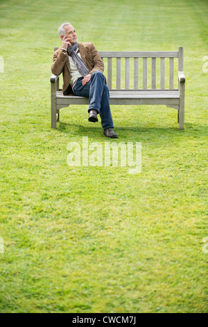 Man sitting on a bench and thinking in a park Stock Photo