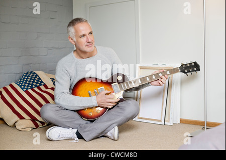 Man playing a guitar at home Stock Photo