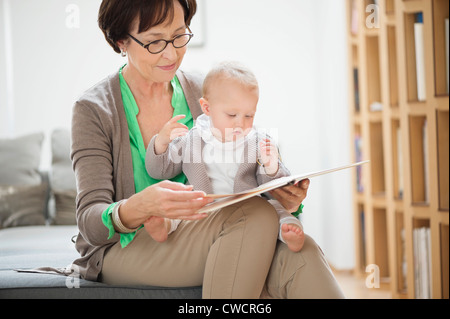 Woman with her granddaughter reading a picture book Stock Photo
