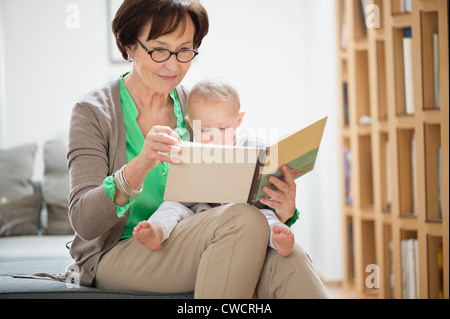 Woman with her granddaughter reading a picture book Stock Photo