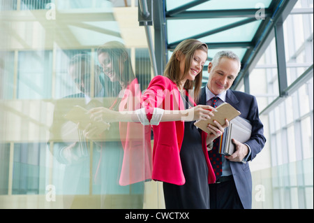 Business executives discussing in an office corridor Stock Photo