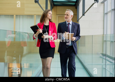 Business executives discussing in an office corridor Stock Photo