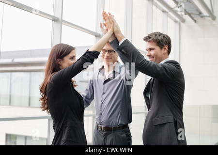 Business executives giving high-five to each other Stock Photo