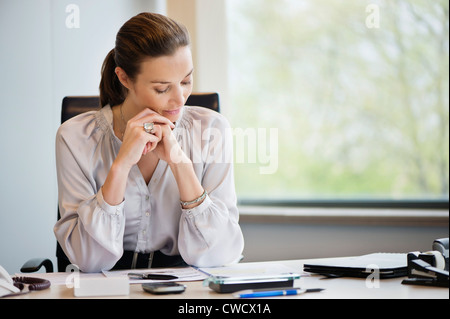 Businesswoman reading documents in an office Stock Photo