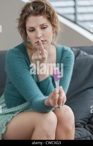 Woman looking sad after checking her pregnancy test Stock Photo