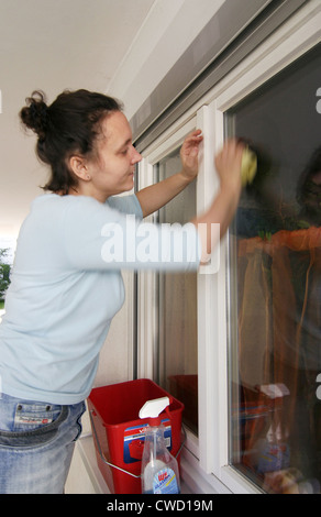 Stressed woman washing windows Stock Photo
