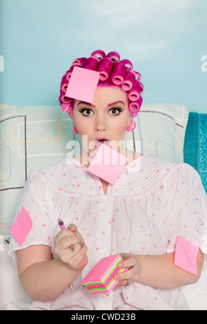 Portrait of shocked woman with sticky notes on herself Stock Photo