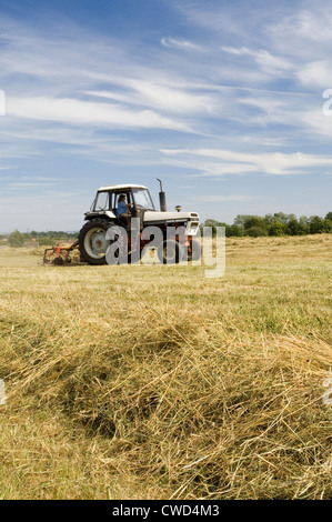 Tractor during hay making in Oxfordshire field. Stock Photo