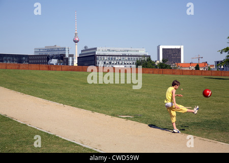 Berlin, child kicking ball in Spreebogenpark