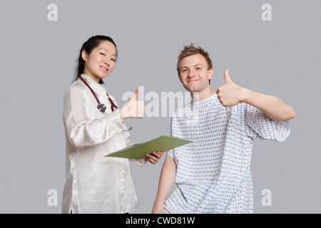 Portrait of happy doctor and patient gesturing thumbs up Stock Photo