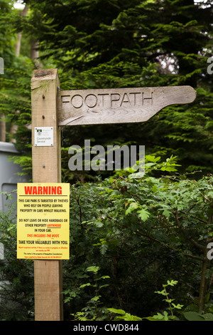 rustic wooden finger footpath sign with warning notice 'not to leave valuables in your car' Stock Photo