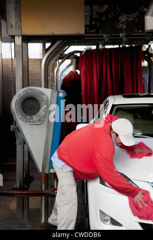 Employee wiping vehicle after washing in car wash Stock Photo