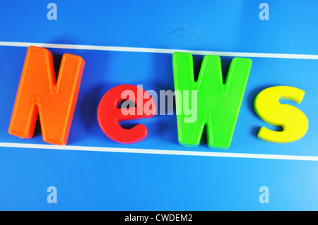 'News' message made of colorful letters on blue background Stock Photo