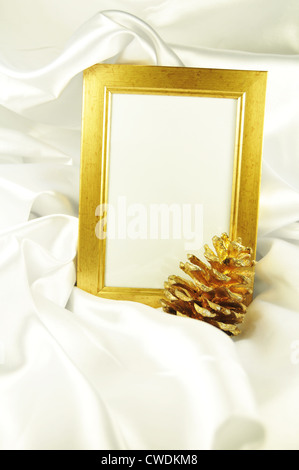 Beautiful golden frame against white silk satin Stock Photo