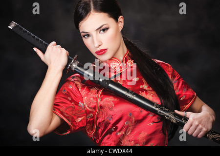 Pretty woman holding katana weapon Stock Photo