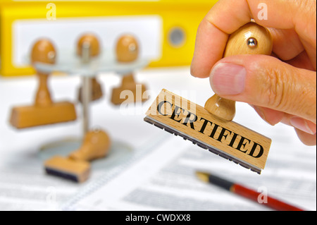 rubber stamp in hand marked with certified Stock Photo