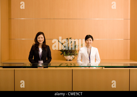 Two businesswomen standing at front desk Stock Photo