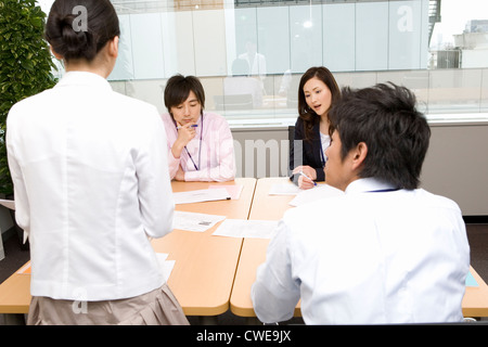 Four businesspeople talking at meeting Stock Photo
