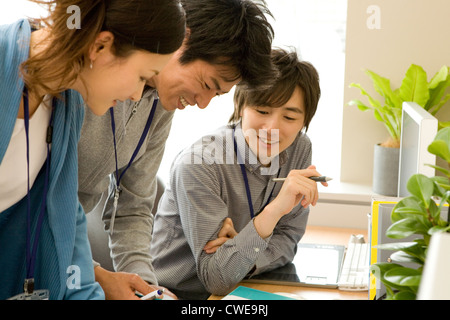 Three businesspeople in casual clothing working at office Stock Photo