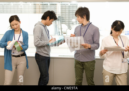 Four businesspeople in casual working by the window Stock Photo