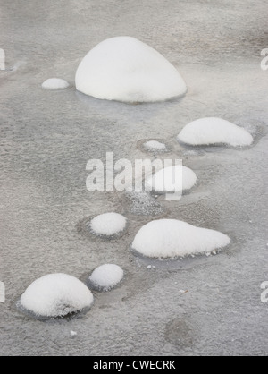 Snow covered rocks and stones in an icy River Dee, near Braemar, Deeside, Aberdeenshire, Scotland, UK. Stock Photo