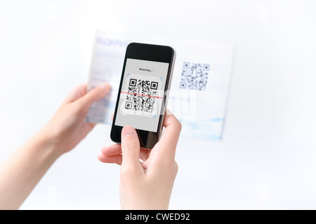 Woman scanning QR code in the magazine on mobile smart phone. Stock Photo