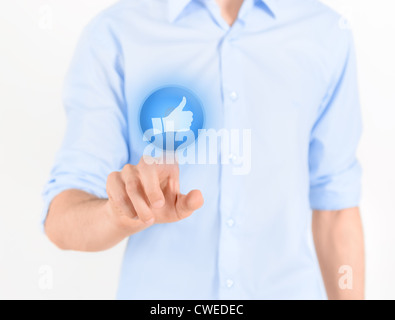 Man touching social media button with thumb up symbol on a virtual screen. Isolated on white. Stock Photo