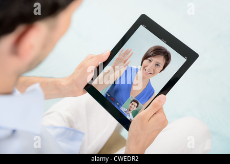 A young couple talking to each other via online video chat. Stock Photo