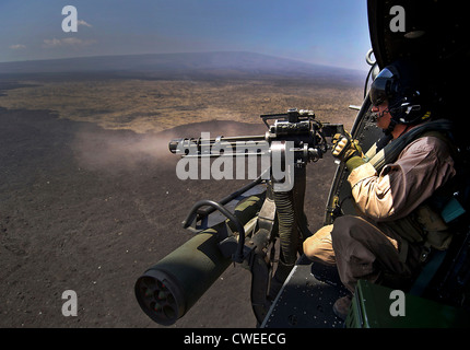 A US Marine fires a 7.62mm GAU-17/A Minigun July 22, 2012, during a live fire combat training mission over the Pohakuloa Training Area, Hawaii during Rim of the Pacific. Stock Photo