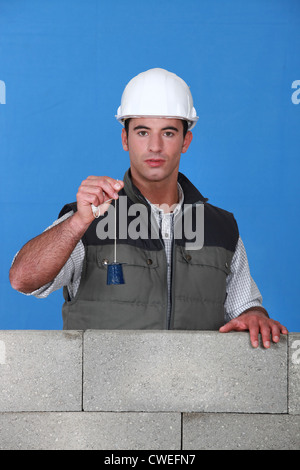Mason using tool to check wall Stock Photo