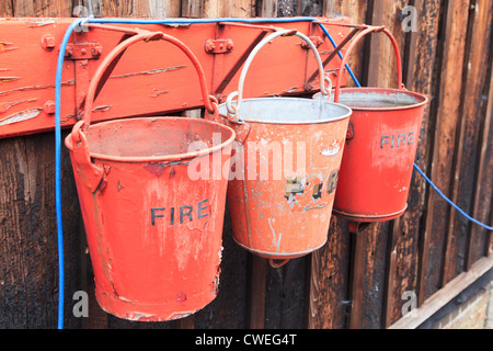 Vintage Fire Buckets with flaking red paint Stock Photo