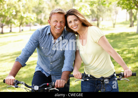 Couple riding bikes in park Stock Photo