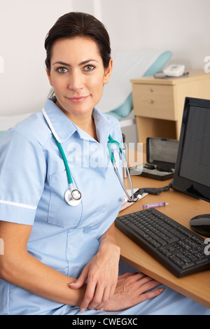 British nurse sitting at desk at work Stock Photo